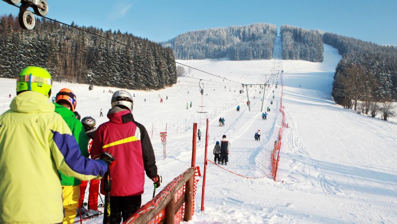 Skiing in Lunz, © weinfranz.at Skiers stand in a queue at the ski lift on a snowy slope.