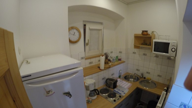 Kitchen vacation apartment 2, © dmgrauszer Small kitchen with fridge, microwave, stove and sink.