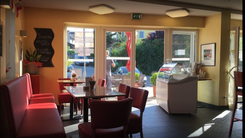 Teufner bakery Indoor seating, © Donau NÖ Tourismus Interior of a bakery with red benches and tables, large windows and an ice cream counter.