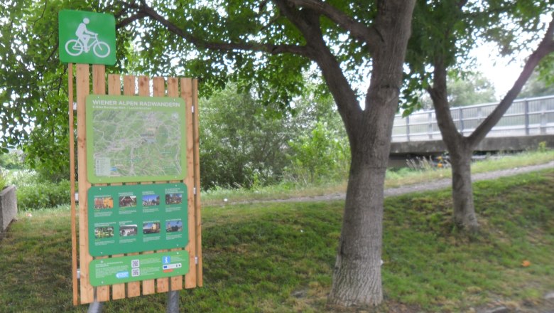 Lanzenkirchen bike start board, © ©Wiener Alpen Bicycle starting point board in Lanzenkirchen with map and information, surrounded by trees.