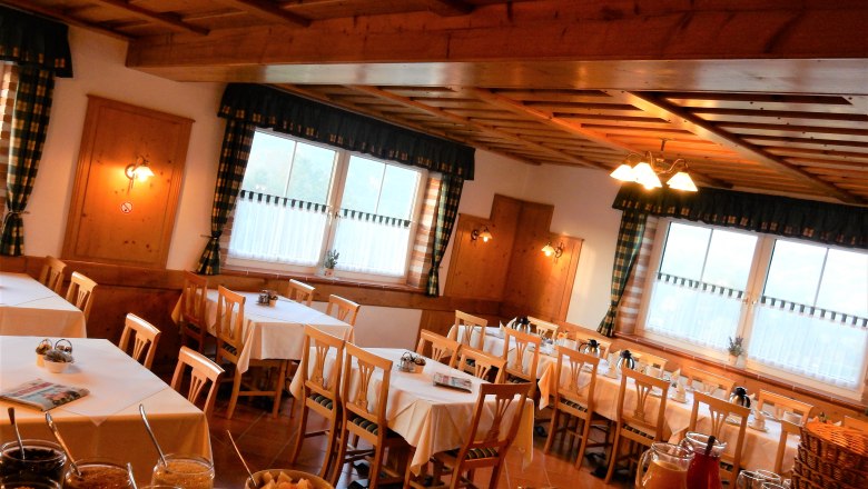Pension Rudi, © Pension Rudi Cozy breakfast room with wooden furniture and laid tables.