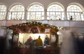 Christmas market at Katzelsdorf Castle, © Wiener Alpen/Stefanie Reisenbauer Christmas-decorated punch stand with lights and people in front of it, Katzelsdorf Castle in the background