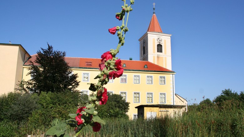 St. Andrä, © Hans Kopitz Church of St. Andrä with a red flower shoot in the foreground.