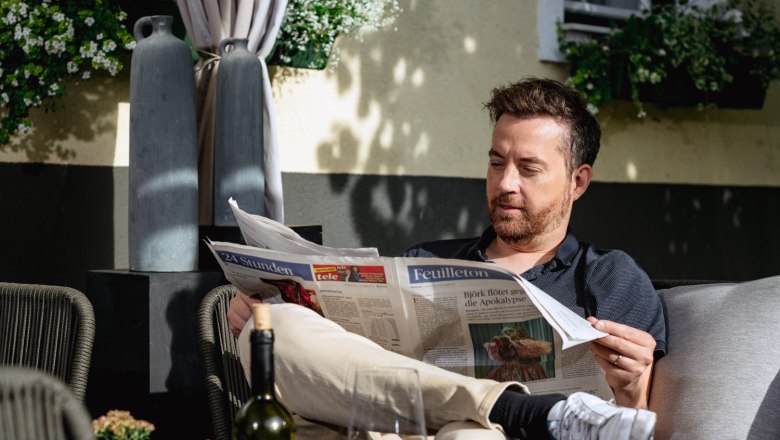 Guest garden at the Edelmann winery & guest room, © Martina Siebenhandl Guest garden at the Edelmann winery & guest room, man reading the newspaper