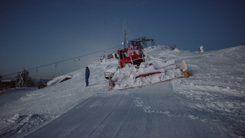Unterberg ski area, © Schigebiet Unterberg | katischweiger.fotography A snow groomer on a snow-covered ski slope at dusk in the Unterberg ski area.