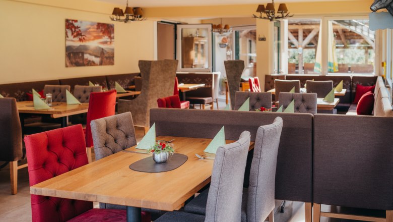 Take a seat & buy from the farm, © Niederösterreich Werbung/Daniela Führer Cozy restaurant with wooden tables and upholstered chairs.