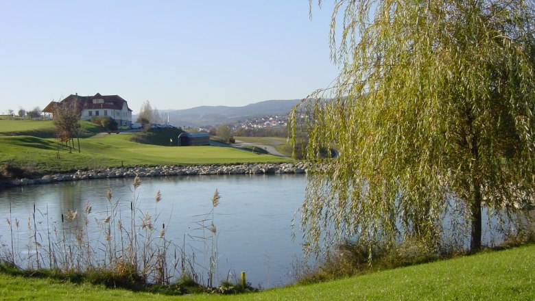 Lengenfeld golf course, © GCL Golf course with pond, trees and a building in the background.