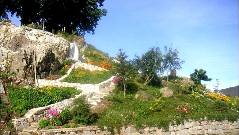 EXPERIENCE: Stone & Garden, © Familie Anderl Rock garden with flowers and steps, surrounded by trees.