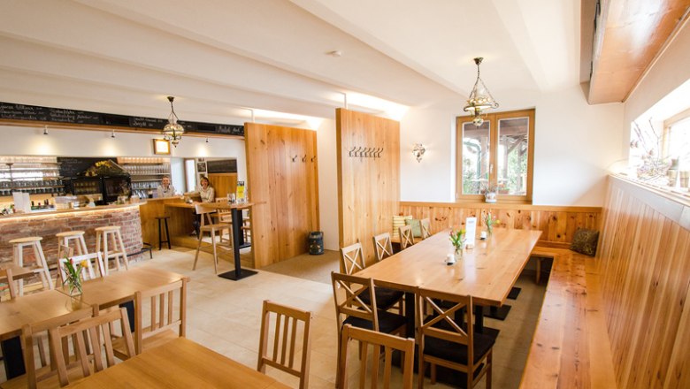 Restaurant Weinbau Klampfl, © hamp.at Cozy guest room with wooden furniture and bar.