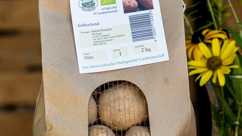 Potatoes, © Martina Siebenhandl A paper sack of organic potatoes with yellow flowers next to it.