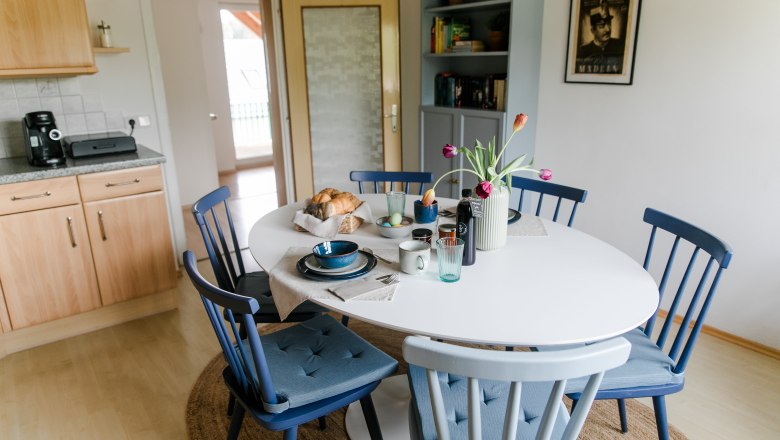 Kitchen with seating, © heiter-weiter.at/Karl Stangl Dining area in a kitchen with round table, blue chairs and breakfast table.