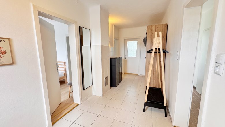 Reading room Hallway, © Christoph Menhofer Bright hallway with tiled floor, mirror, wardrobe and doors to adjoining rooms.