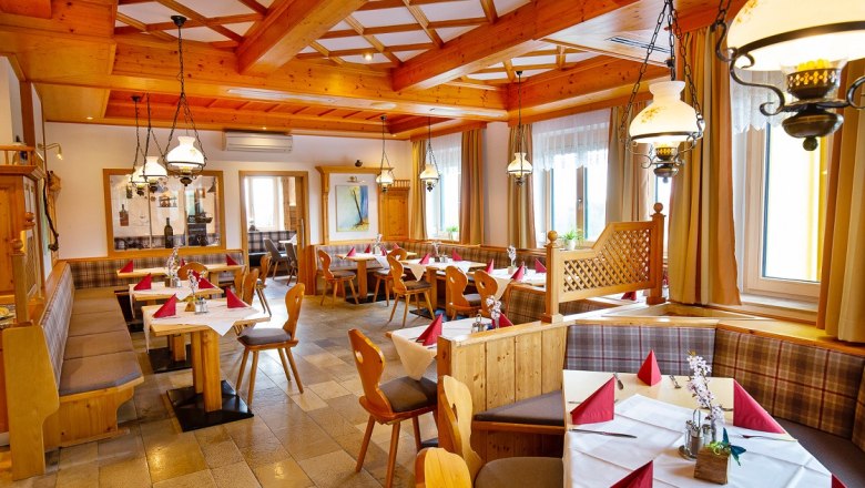 Restaurant, © Hotel Stich Cozy restaurant with wooden furniture and laid tables.