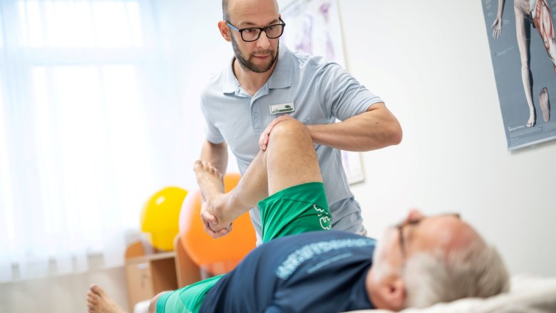 Physiotherapy, © Moorheilbad Harbach A physiotherapist treats the leg of a recumbent patient in a treatment room.