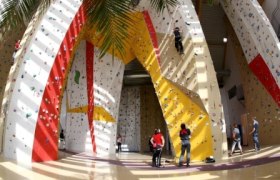 Climbing hall Weinburg, © Gemeinde Weinburg Interior view of a climbing hall with colorful climbing walls and several people climbing.