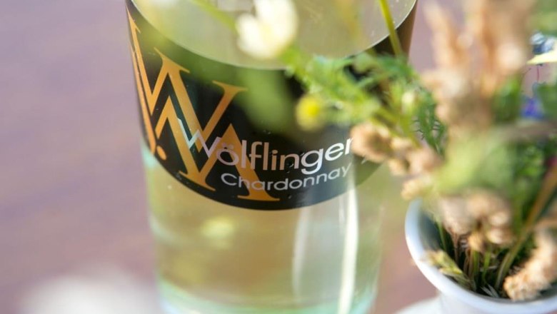 Viticulture Wölflinger, © Fotohaus Hans Krist Close-up of a wine bottle labeled 'Wölflinger Chardonnay' next to a bouquet of flowers.