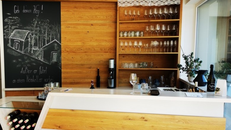 Tasting room and bar, © Weinstraße Weinviertel Tasting room with wooden counter, wine glasses and blackboard with drawing.