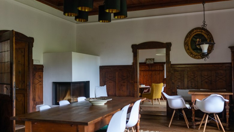 Dining room, © Wiener Alpen - Lierzer Dining room with wooden table, white chairs and fireplace.