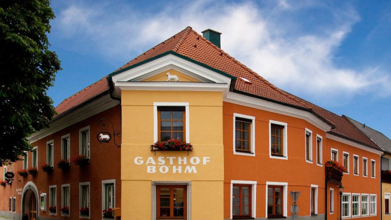 Gasthof Böhm, © GH Böhm A traditional inn with an orange and yellow façade and red roof tiles under a blue sky.