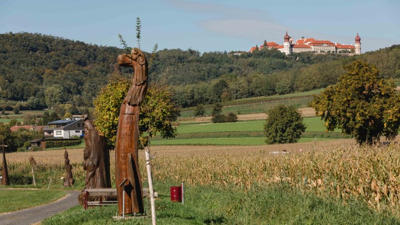 On the sculpture trail with a view of Göttweig Abbey, © Doris Schwarz-König Sculpture trail with wooden sculptures and a view of Göttweig Abbey in the distance.