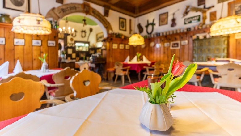Guest room, © Christian Kremsl Cozy guest room with wooden furniture, tablecloths and flower vases.