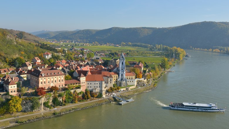 Aerial view, © Gregor Semrad Aerial view of a village on a river with a ship, surrounded by hills and vineyards.