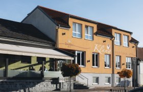 Inn directly on the market square of Echsenbach, © Niederösterreich Werbung/David Schreiber Gasthof Klang in Echsenbach with a yellow façade and large windows.