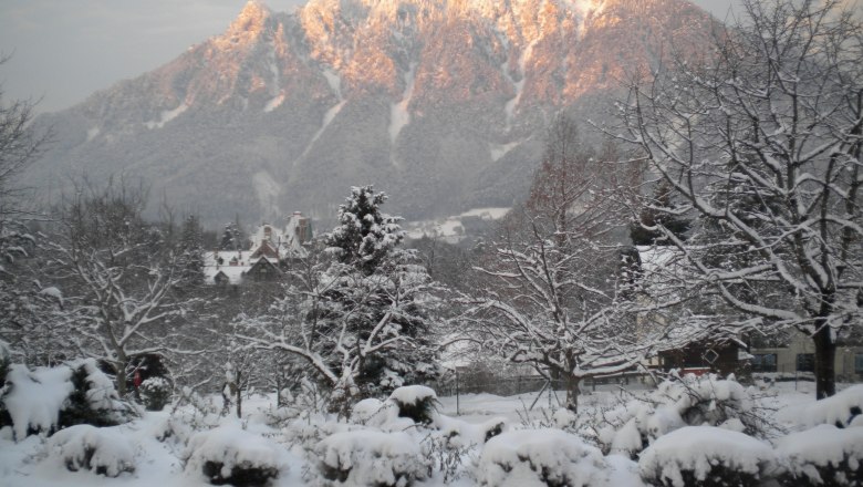 Winter at the Flackl-Wirt, © Flackl-Wirt Snow-covered landscape with mountains in the background, illuminated by the evening sun.