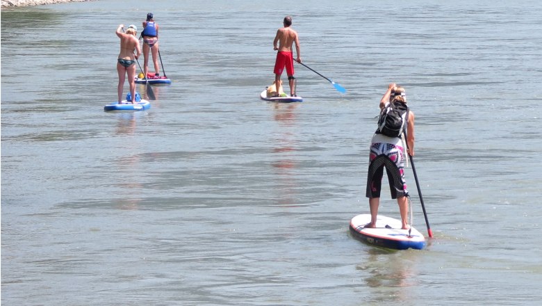 Stand up paddling, © www.standuppaddeln.at Four people stand up paddling on a river.