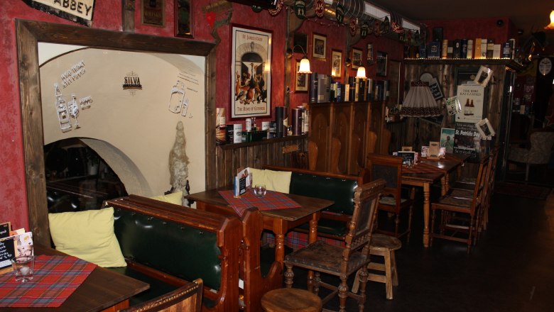 Area opposite the bar, © Mary´s Scottish Coffeepub Cozy bar with wooden furniture, red walls and Irish decorations.