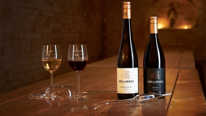 Wine enjoyment, © Markus Lang-Bichl Two wine glasses and two bottles of wine on a wooden table in a wine cellar.
