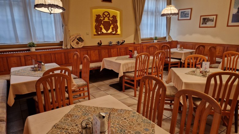Bäckerstüberl, © Karin Stranz Cozy café with wooden furniture and decorated tables.