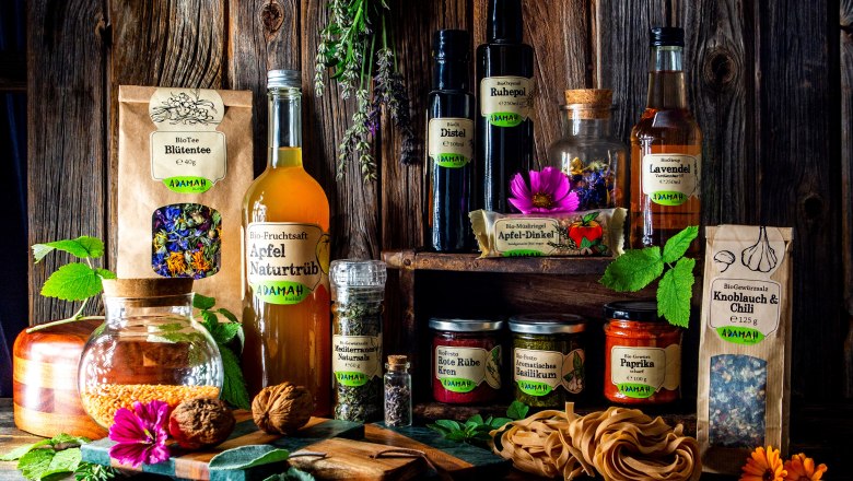 Product range, © Sandra Tauscher Various ADAMAH organic products arranged on a rustic wooden table.