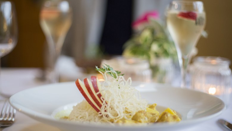 Alpen-Aktiv-Landgasthof zur Schubertlinde, © Patrick Haberler A plate with rice, apple slices and a garnish on a laid table.