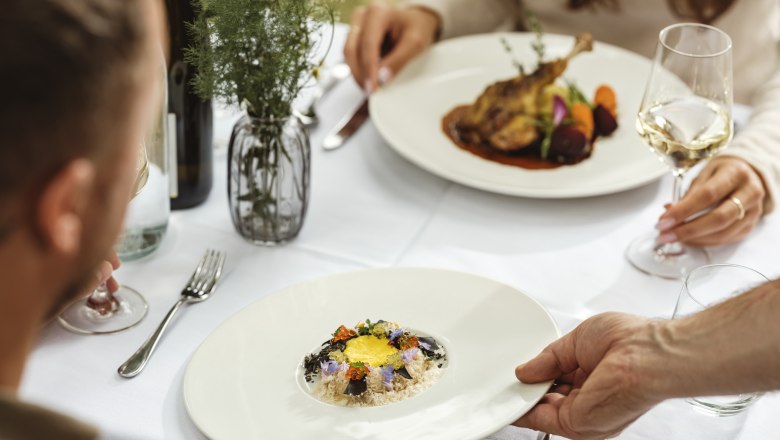 Genusswirtschaft Mailberg, © Weinviertel Tourismus / Michael Reidinger An elegant restaurant meal with two people sitting at a table. A plate with an artfully arranged dish is served.