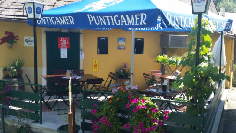 Stiegenwirtshaus Gloggnitz, © Stiegenwirtshaus/Stummer Outdoor area of a pub with blue parasols and flowers.