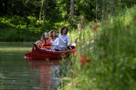 Canoeing in the water park, © DIE GARTEN TULLN Family in a canoe on a river in the countryside.