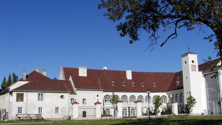 The Freiherr von Joksch - directly in Katzelsdorf Castle, © Gemeinde Katzelsdorf Katzelsdorf Castle with its red roof and white walls, surrounded by trees and lawns.