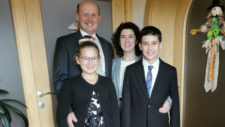Rieder family, © Fam. Rieder A family in formal dress stands smiling in a hallway.