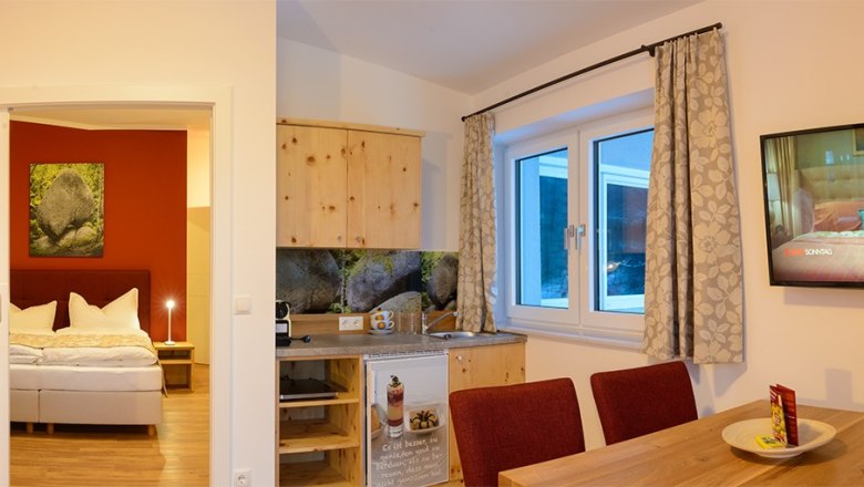 Heart stone room, © Wirtshausbrennerei Krenn, Johann Frank Cozy room with bed, kitchenette and dining table.