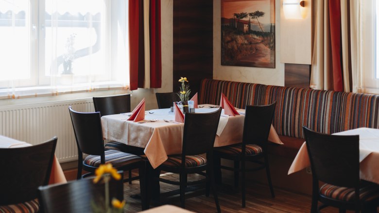 Refreshments in Arbesbach, © Niederösterreich Werbung/David Schreiber Cozy restaurant with a table setting, red napkins and flowers.