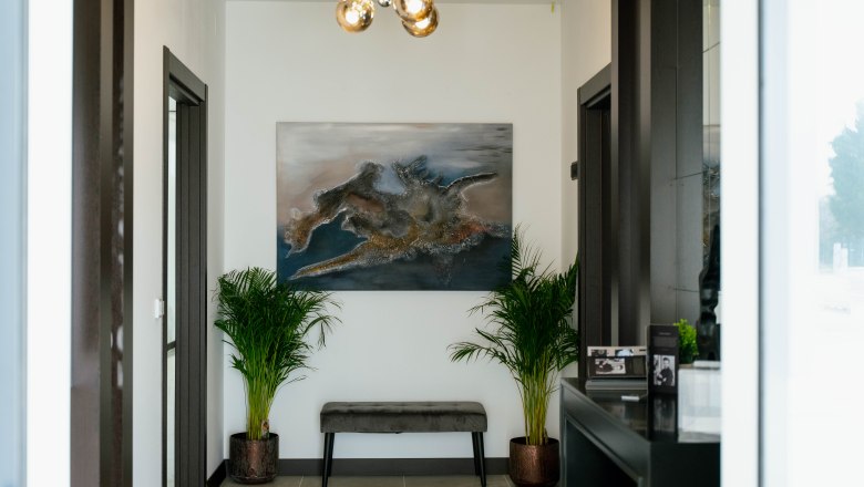 Hotel Lamede, © Hotel Lamede Modern hotel corridor with artwork and plants.