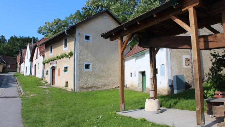 Wine cellar lane Althöflein, © Weinviertel Tourismus Historic buildings in Althöflein with an old timber press shelter in the foreground.