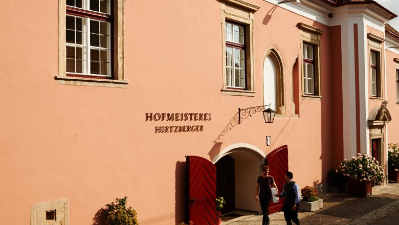 Hofmeisterei in the Wachau World Heritage Region, © Hofmeisterei Hirtzberger/Julius Hirtzberger Historic Hofmeisterei Hirtzberger building with pink façade and red doors in the Wachau region.