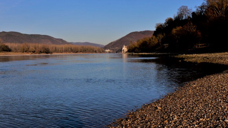 Bathing beach around the campsite, © Szilágyi Riverbank with pebble beach and wooded hills in the background.
