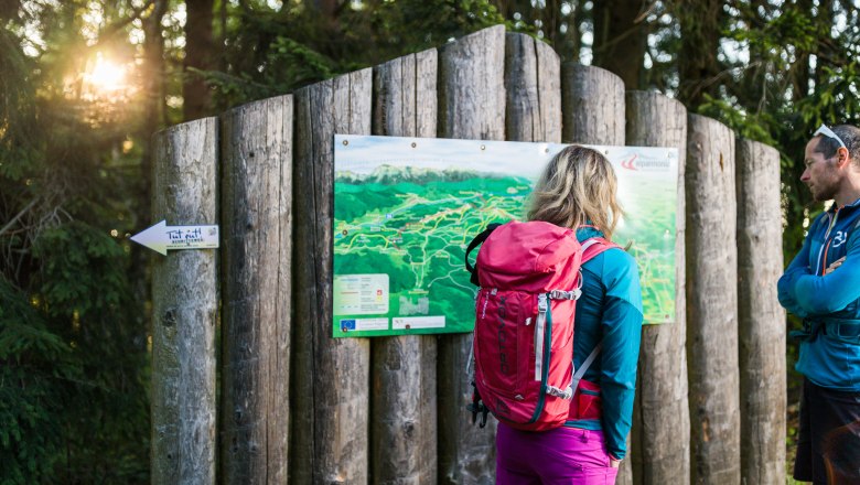 On the alpannonia long-distance hiking trail, © Wiener Alpen/Martin Fülöp Two hikers look at a hiking map in the forest.
