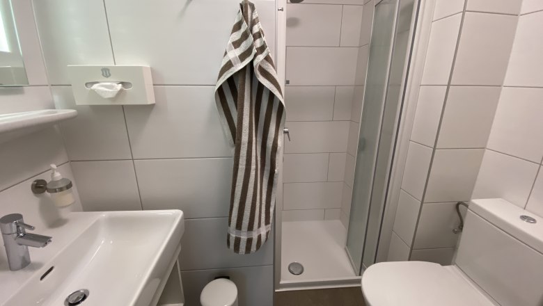 Summer room, © Privatzimmer Leeb Modern bathroom with shower, washbasin and toilet.