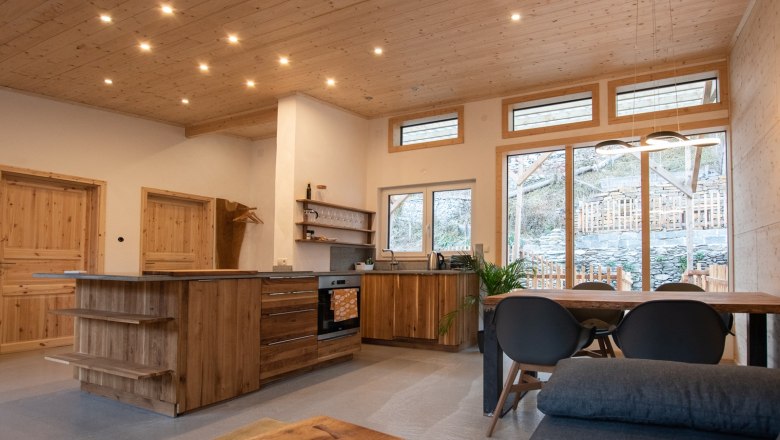 Open kitchen, © Silbersberg Cottage Modern open kitchen with wooden furniture and large windows.