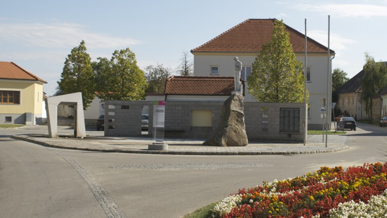 Mailberg, © Herbert Weil Monument in Mailberg with statue on a rock, surrounded by buildings and flowerbeds.