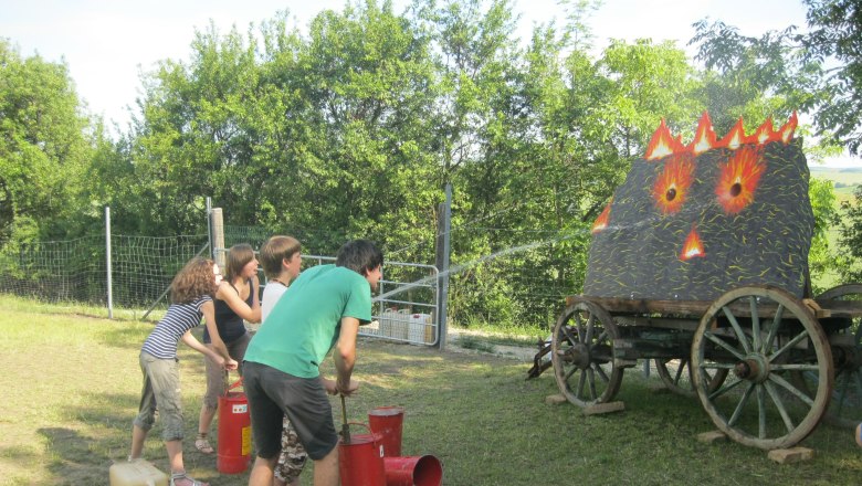 Fire extinguishing, © Alpaka Freizeitpark People extinguish a simulated fire on a wagon with water jets.